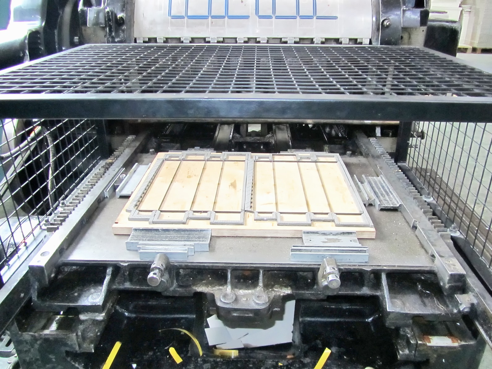 Massicot de façonnage coupant une pile de documents imprimés dans l'atelier Signum